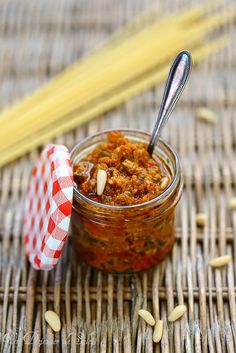 a jar filled with food sitting on top of a table next to two straws