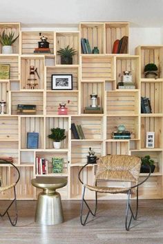 two chairs and a table in front of a wooden wall with bookshelves on it