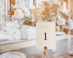 the table numbers are placed on top of each other near vases with flowers in them