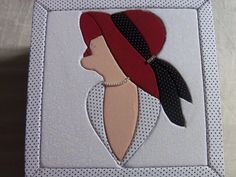 a woman's head with a red hat and black scarf on top of a white box