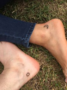 two people sitting on the ground with their feet crossed and one has a small star tattoo