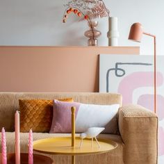 a living room with a couch, table and two candles on the coffee table in front of it