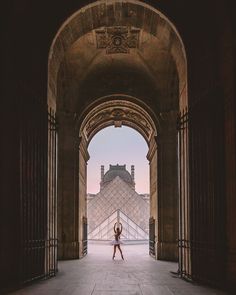 a woman is dancing in front of the pyramid