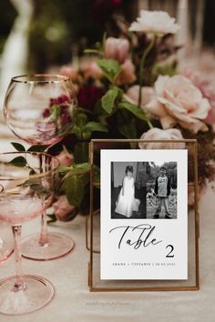 a table with wine glasses and flowers on it