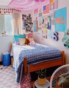 a bedroom decorated in pink, blue and white with pictures on the wall above the bed