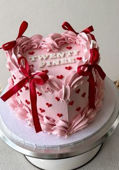 a heart shaped cake with red bows on top