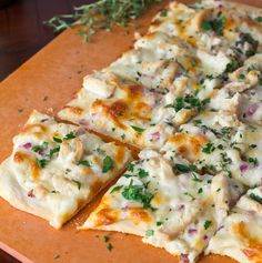 the pizza is cut into four pieces and ready to be put in the oven on the cutting board