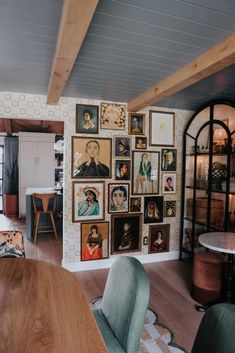 a dining room table with chairs and pictures on the wall