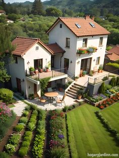 an aerial view of a house with many plants and flowers in the front yard area