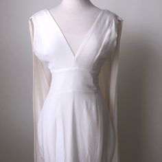 This Gorgeous White Silk Dress Is Brand New With No Stains Or Blemishes. Perfect For A Classy Occasion. This Deep V Plunge Dress Is Super Classy And Sexy. It Features This Beautiful Flowy, Whimsical Cape Fabric That Is Just Stunning! It Is Also Sinched Around The Waist To Extenuate A Slim Look. White V-neck Dress With Sheer Sleeves, White Sheer V-neck Mini Dress, Elegant Mini Dress With Sheer Sleeves And V-neck, Elegant V-neck Mini Dress With Sheer Sleeves, Feminine Sheer V-neck Mini Dress, Fitted Cream Mini Dress With V-neck, Cream Fitted V-neck Mini Dress, Cream Fitted Mini Dress With V-neck, White Fitted Dress With Open Front