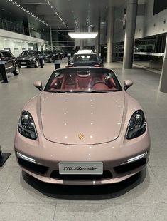 a pink sports car parked in a showroom