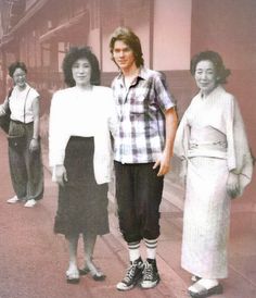 three women standing next to each other in front of a building