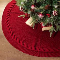 a small christmas tree on top of a red round rug