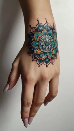 a woman's hand with a flower tattoo on it