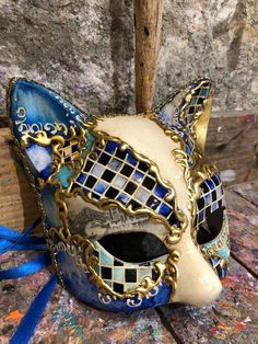 Original hand-painted Venetian mask embellished with stucco decoration and non-toxic acrylic colours. Elegant cat mask decorated with baroque friezes and glitter. -Made in Italy hypoallergenic and non-toxic material/resin. -Dimensions/18x18 Unisex -History of the mask/a double legend intertwines the fate of this cat-like mask. From ancient texts it appears to be a "Sacred" animal for the city of Venice as it would have saved it from the terrible plague of the 16th century by managing to defeat t Blue Venetian Mask For Carnival, Blue Venetian Masks For Carnival, Blue Venetian Eye Mask, Venetian Masks Art, Elegant Cat, Alice In Wonderland Dress, Venice Mask, Magical Boy, Carnival Mask