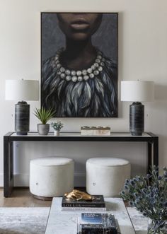 a living room filled with furniture and a painting on the wall above it's coffee table