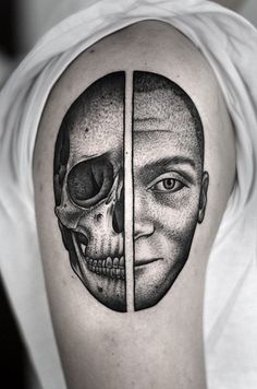 a man's half - sleeved tattoo with two faces and a skull