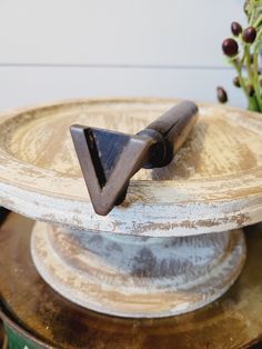 an old wooden cake plate with a metal triangle on it