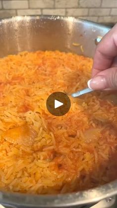 someone is stirring rice in a pan with a spatula to stir the food together