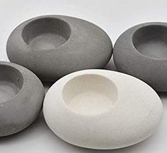 four gray and white vases sitting next to each other