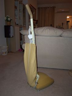 an ironing board is sitting on the floor in front of a couch and pillows