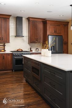 a large kitchen with wooden cabinets and white counter tops on a hard wood flooring