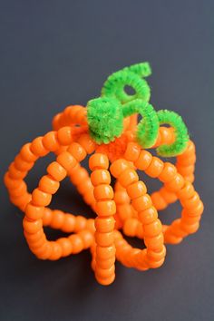 an orange and green object is sitting on a black surface with some sort of spirals attached to it