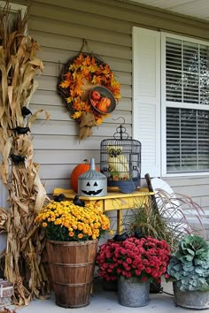 a porch decorated for halloween with pumpkins, corn stalks and other fall decorations on it