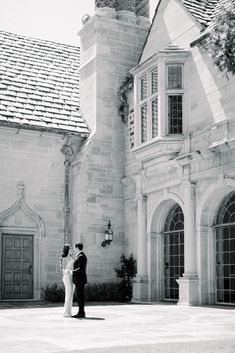 a bride and groom standing in front of a large building