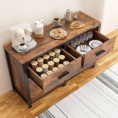 an open drawer on the side of a table with coffee cups and cookies in it