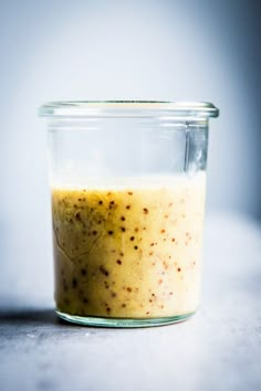 a glass jar filled with food sitting on top of a white countertop next to a blue wall