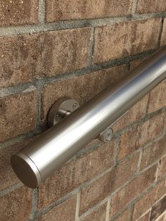 a stainless steel door handle on a brick wall