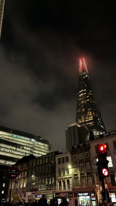 a very tall building towering over a city at night