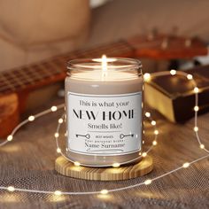 this is what your new home smells like candle with string lights around it and a guitar in the background