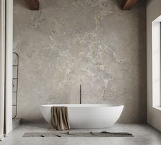 a large white bath tub sitting in a bathroom next to a wall with exposed wood beams