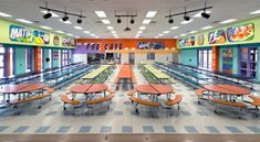 an empty cafeteria with many tables and benches