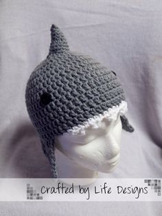 a crocheted gray and white hat on top of a mannequin head