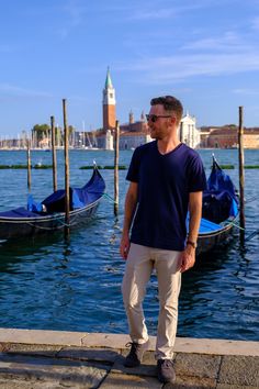 a man standing on the edge of a pier next to gondolas