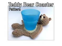 a crocheted teddy bear with a blue cup in it's paws and the words teddy bear coaster pattern