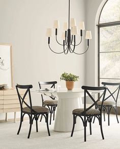 a dining room table with four chairs and a potted plant on the table next to it