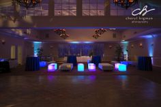 an empty dance floor is lit up with blue and purple lights for a wedding reception