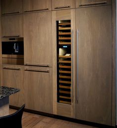 a kitchen with wooden cabinets and granite counter tops, along with a wine rack on the wall