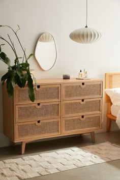 a bedroom scene with focus on the dresser and bed sideboard, which is decorated in wicker