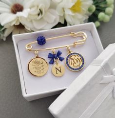 a white box with some gold and blue items in it's packaging next to flowers