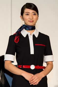 a woman is standing on the runway wearing a black and white dress with red accents