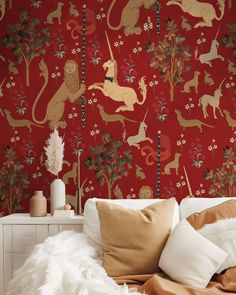 a red wallpaper with animals and flowers in the background is featured on a bed