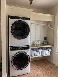 a washer and dryer sitting next to each other in a room with wooden floors