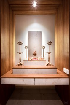 a white and brown room with some candles on the counter in front of an art work