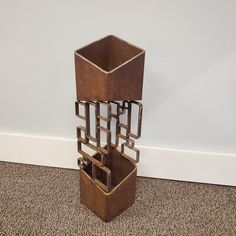 a tall metal vase sitting on top of a carpeted floor