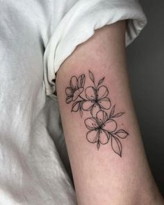 a black and white photo of a flower tattoo on the right arm, with small flowers in it